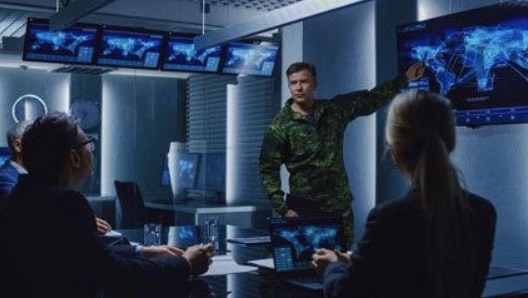 Picture of a man from The National Guard showing a man and two women a map of the world and the countries